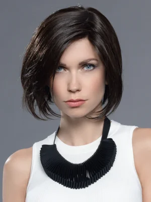 Woman with short brown hair and a black statement necklace on a grey background.