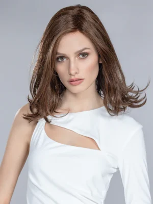 A woman with shoulder-length brown hair wearing a white Add In | Top Power Collection | Remy Human Hair with a cut-out detail.